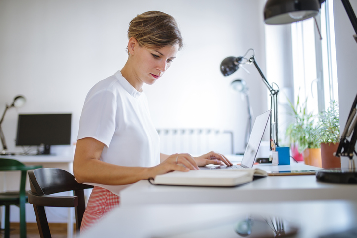 Woman looking at notebook in office hub