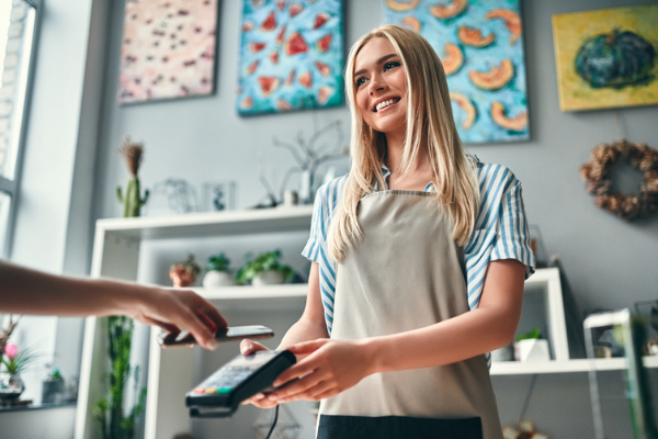 employee holding card reader for someone holding their phone