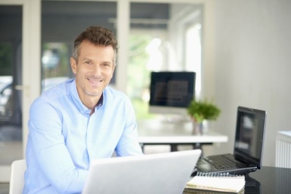 Man sitting while smiling at you