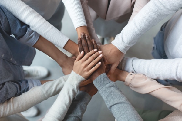 people with hands gathered together