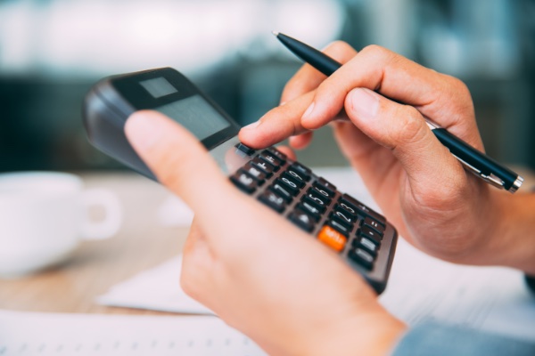 hands holding calculator pressing buttons